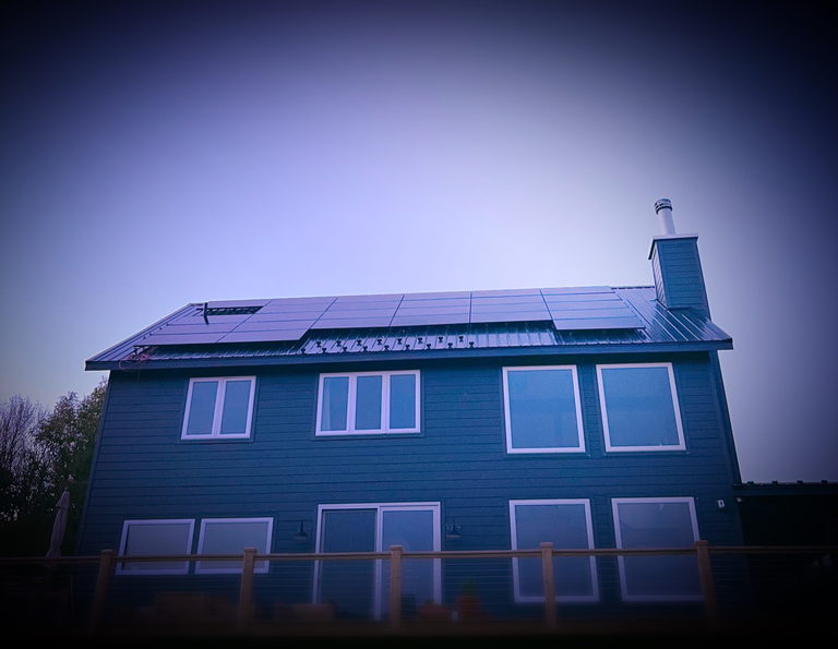 A two-story home with rooftop solar at dusk